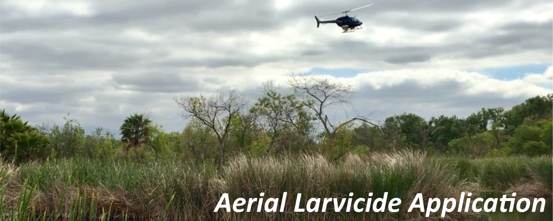 A helicopter applying a granular larvicide to a body of water A helicopter applying a granular larvicide to a body of water